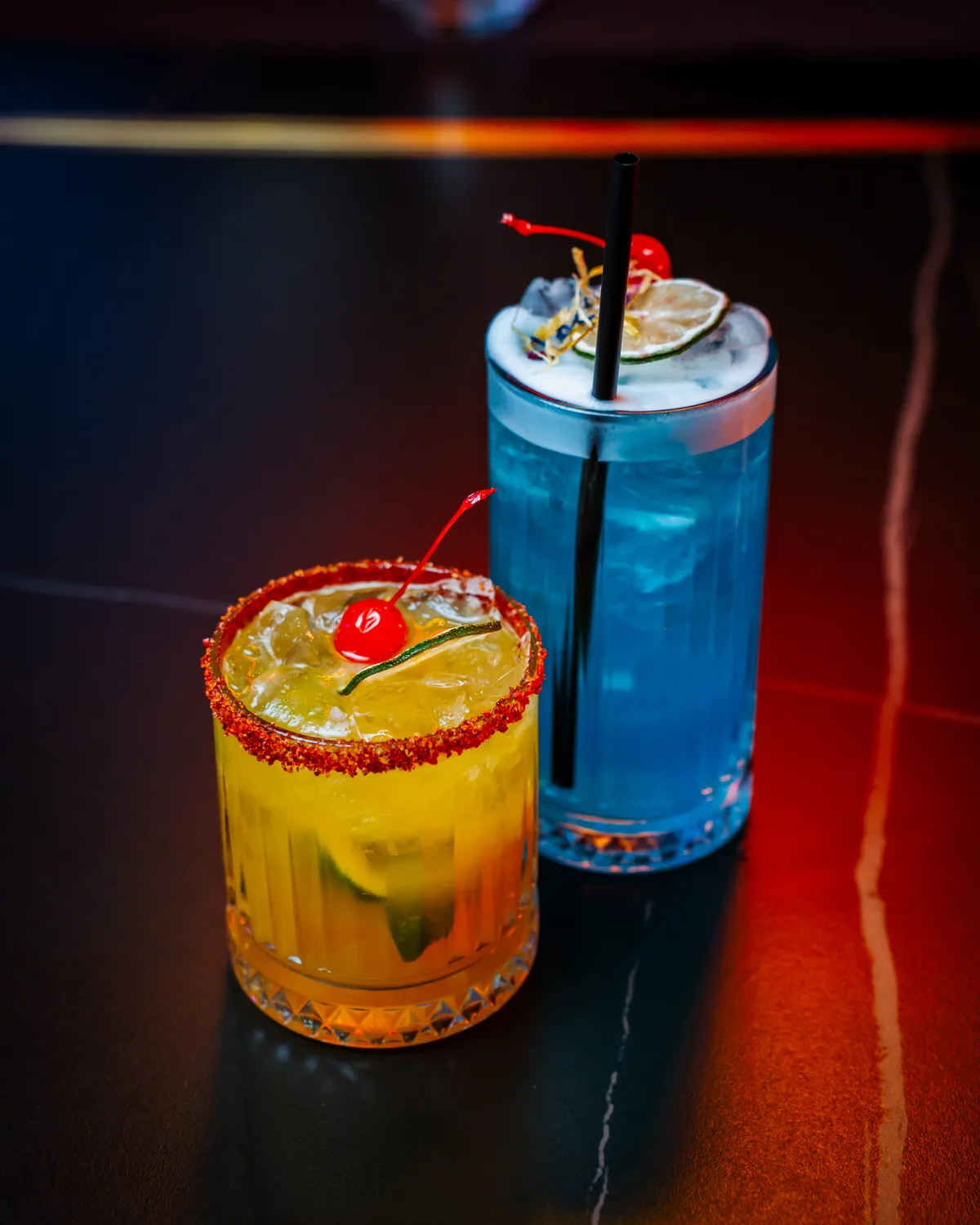 Due cocktail di Ardito's al bancone, con agrumi e ciliegie